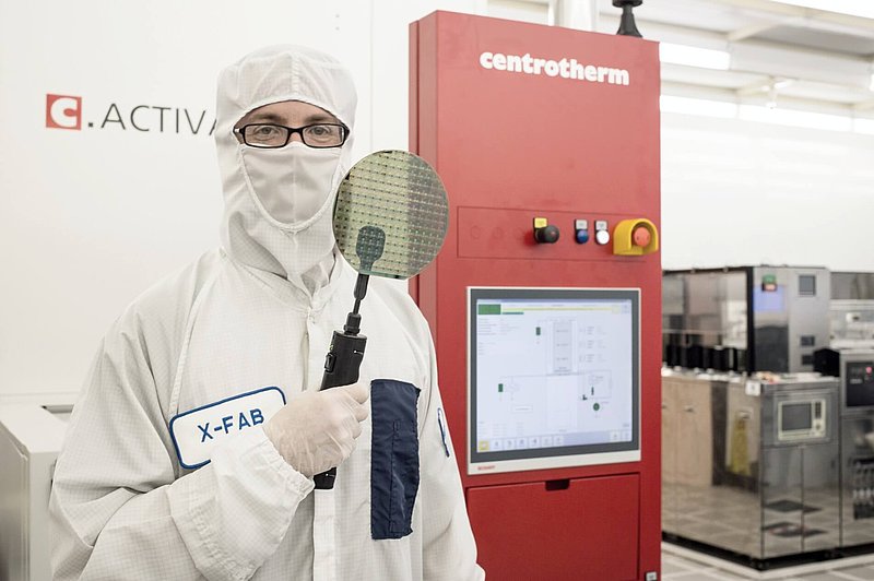 an operator holding SiC wafer in cleanroom